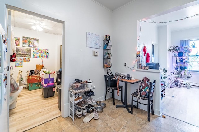 interior space featuring hardwood / wood-style flooring, ceiling fan, and crown molding