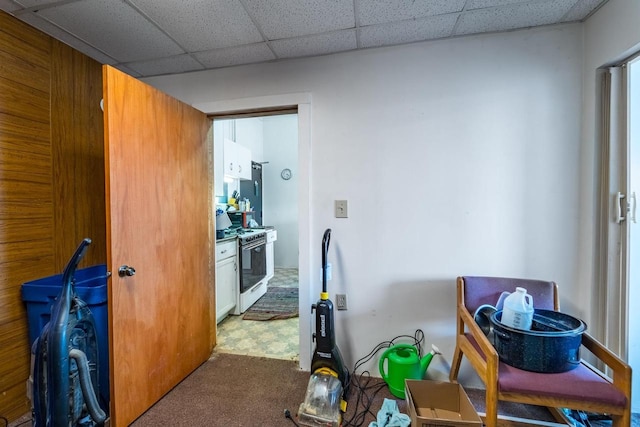 kitchen with carpet, a paneled ceiling, and gas range gas stove