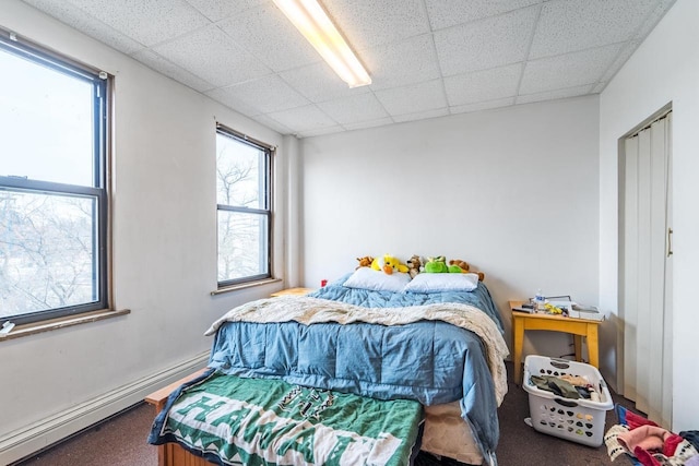 bedroom featuring a paneled ceiling, carpet, and a baseboard radiator