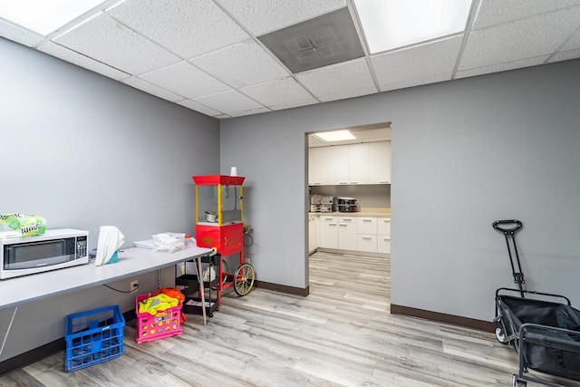 office space with a paneled ceiling and light hardwood / wood-style flooring