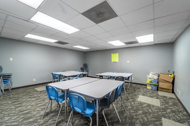 rec room with a paneled ceiling and dark carpet