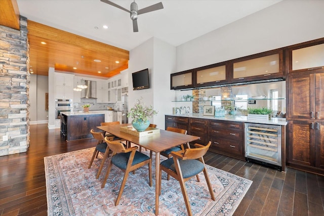 dining room with dark hardwood / wood-style flooring, wine cooler, and ceiling fan