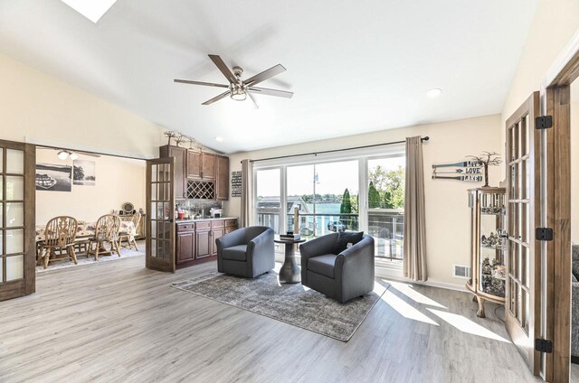7134 N Tichigan Rd, Waterford, WI 53185 - living area with french doors, light wood-style floors, vaulted ceiling, and a ceiling fan