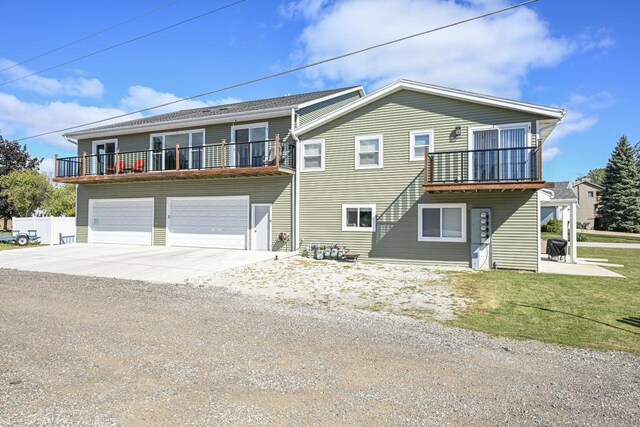 7134 N Tichigan Rd, Waterford, WI 53185 - view of front facade with concrete driveway, a balcony, an attached garage, and a front yard