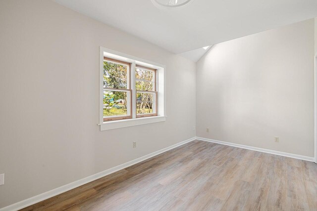4705 Highland Park Dr, Slinger, WI 53086 - spare room featuring light wood-style floors, baseboards, and vaulted ceiling