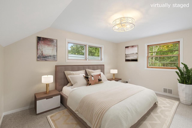 bedroom featuring lofted ceiling and light carpet