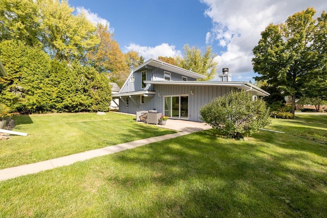 4705 Highland Park Dr, Slinger, WI 53086 - rear view of house featuring a lawn, a patio, and board and batten siding