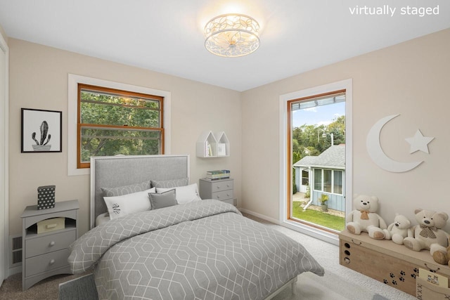 carpeted bedroom featuring multiple windows