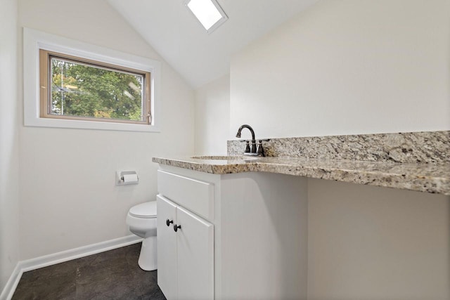 bathroom with vanity, vaulted ceiling, and toilet