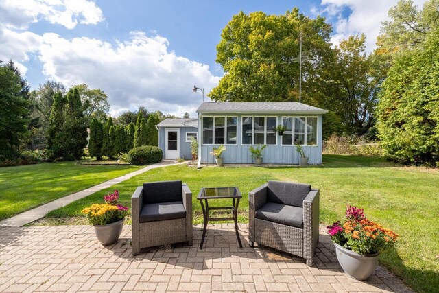 4705 Highland Park Dr, Slinger, WI 53086 - back of property featuring board and batten siding, a lawn, and a patio area