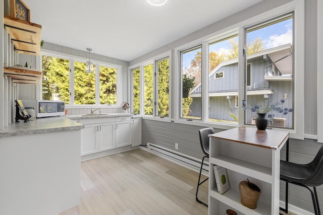 sunroom with baseboard heating and sink