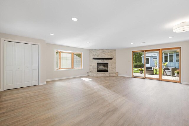 4705 Highland Park Dr, Slinger, WI 53086 - unfurnished living room featuring light wood-style floors, baseboards, a stone fireplace, and recessed lighting