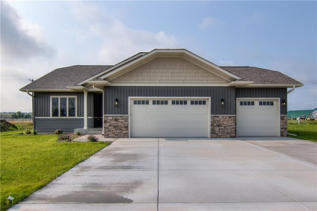 view of front of home featuring a garage, a water view, and a front lawn