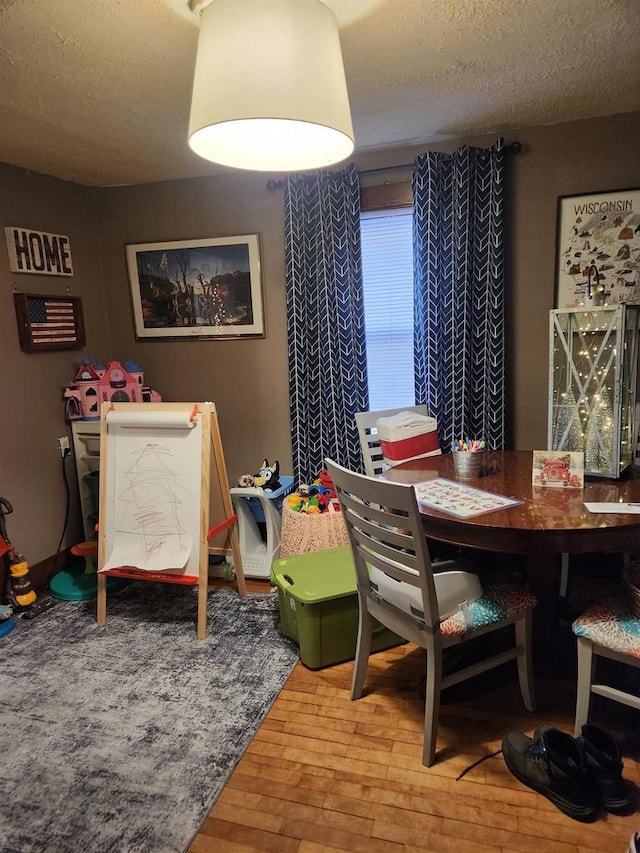 dining room with a textured ceiling and hardwood / wood-style flooring