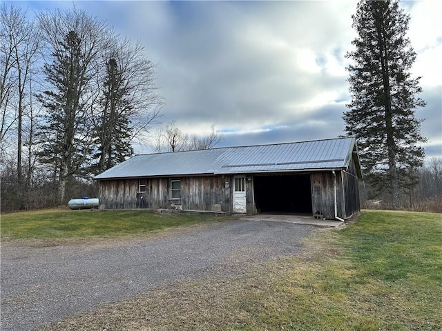 view of front of property with an outdoor structure and a front lawn