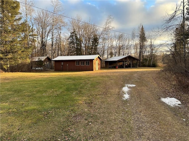 view of yard with a carport and an outbuilding