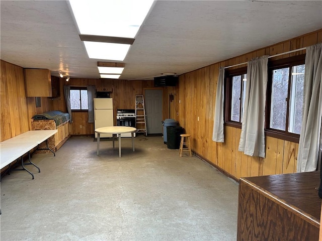 basement with white fridge and wooden walls