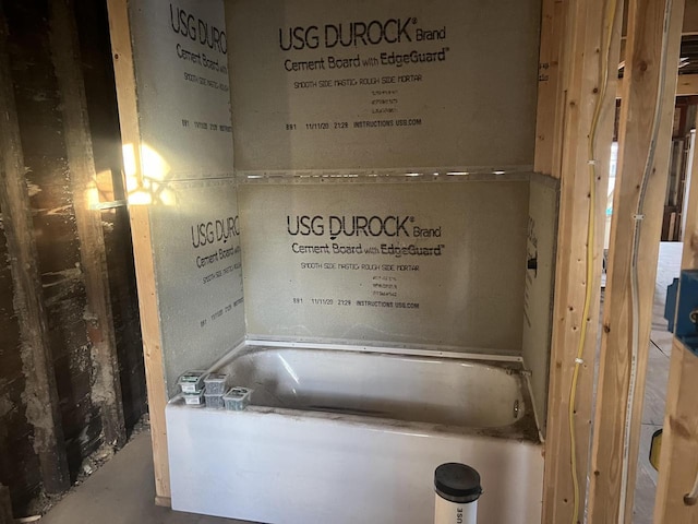 bathroom featuring concrete flooring and a bath