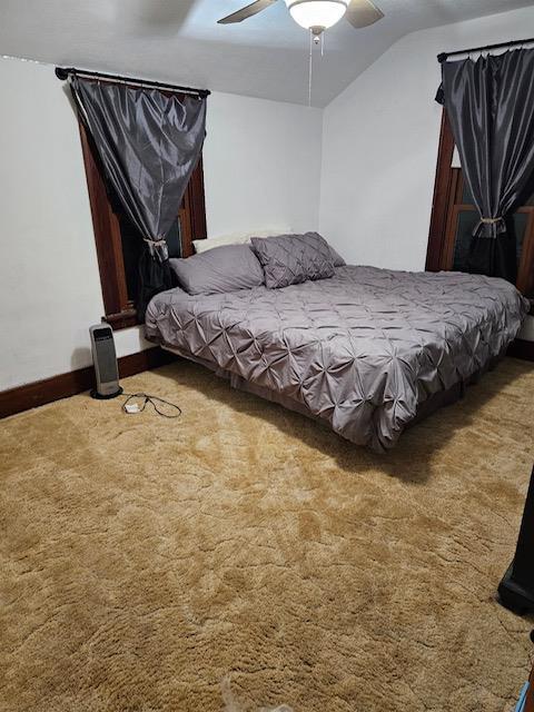 bedroom featuring carpet flooring, ceiling fan, and vaulted ceiling