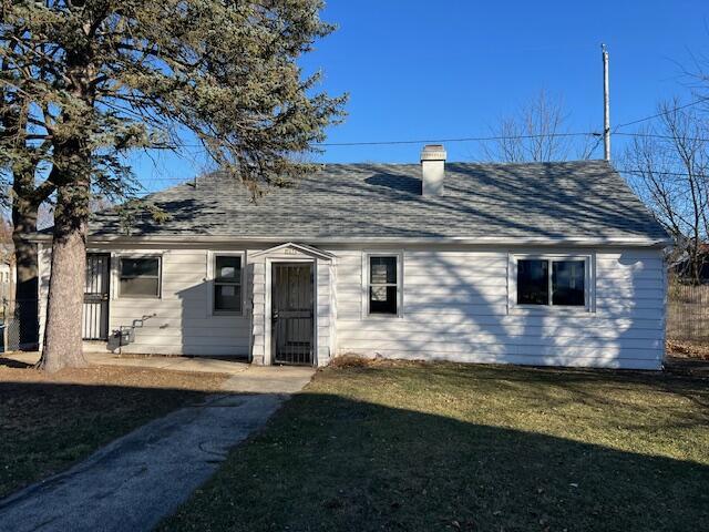 rear view of property with a lawn