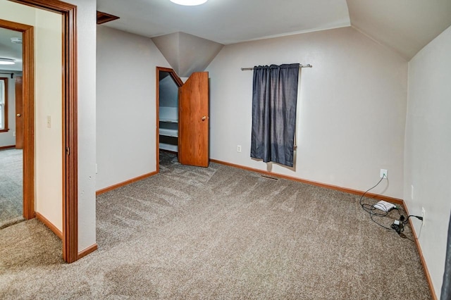 additional living space featuring carpet flooring and vaulted ceiling