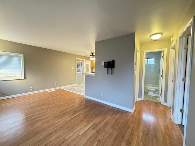 spare room featuring ceiling fan, light wood-type flooring, and a wealth of natural light