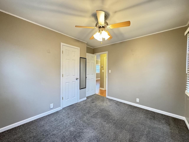 unfurnished bedroom featuring dark carpet, ceiling fan, and ornamental molding