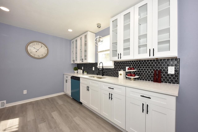 kitchen featuring white cabinets, sink, decorative light fixtures, dishwasher, and light hardwood / wood-style floors