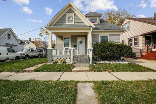 bungalow with a front lawn and covered porch