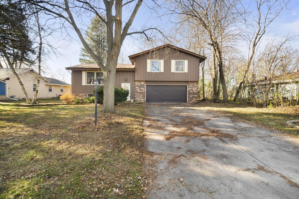 split level home featuring a front yard and a garage