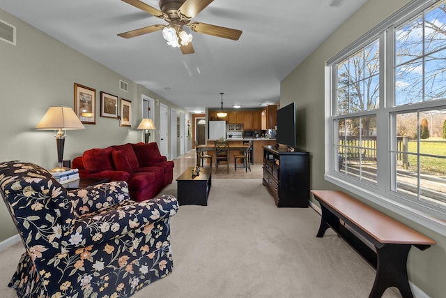 carpeted living room with ceiling fan