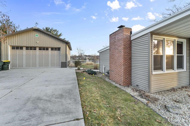 view of side of home featuring an outbuilding, a garage, and a lawn