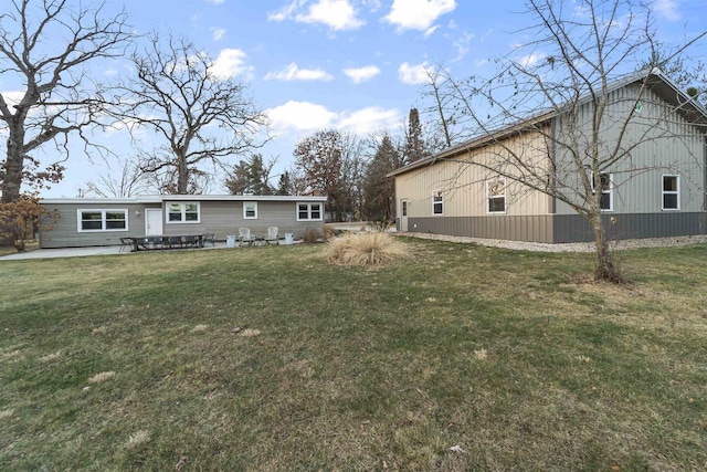 back of house with a patio area and a lawn