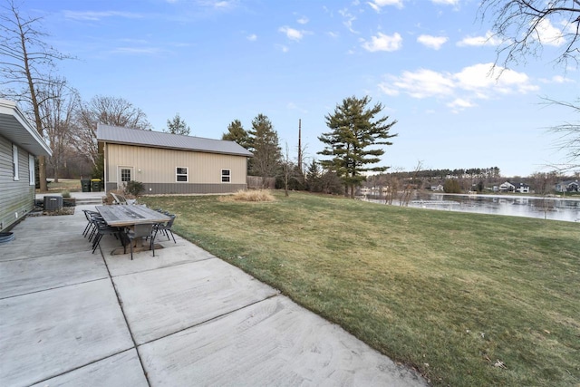 view of yard featuring a water view, central AC, and a patio area