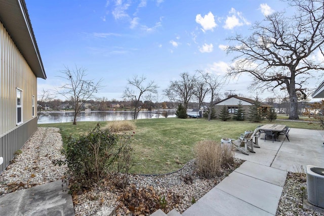 view of yard with a water view, a patio, and central AC unit