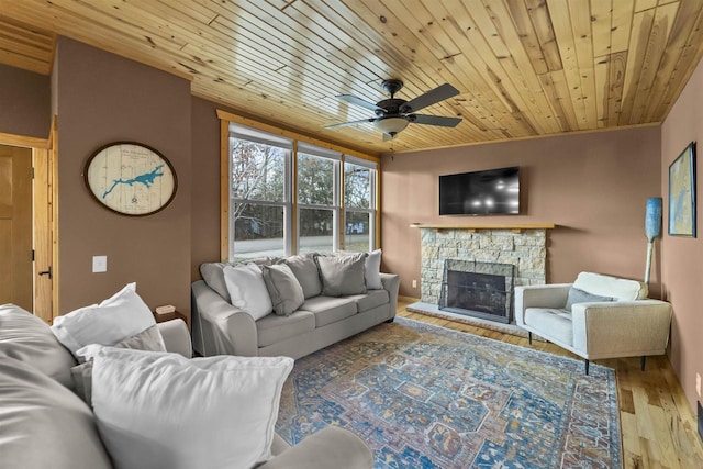 living room featuring ornamental molding, wood ceiling, ceiling fan, a fireplace, and light hardwood / wood-style floors