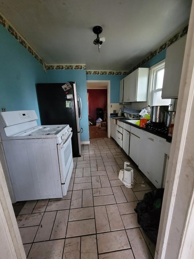 kitchen with white range with electric stovetop, white cabinets, and light tile patterned floors