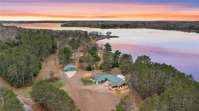 aerial view at dusk featuring a water view