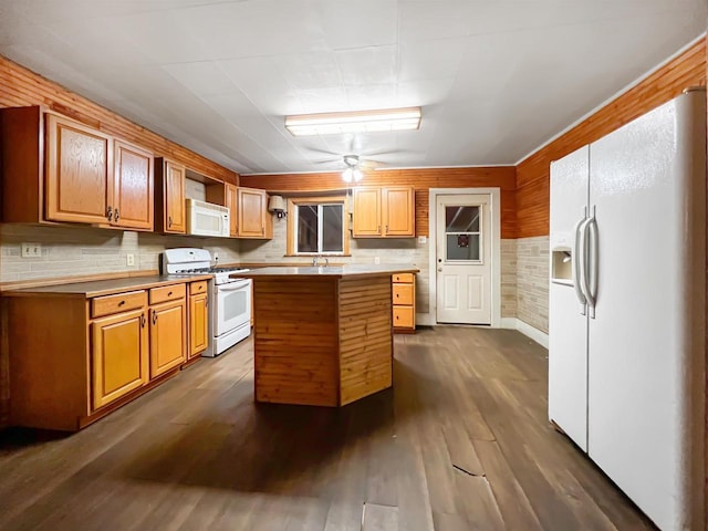 kitchen featuring ceiling fan, a center island, dark wood-type flooring, backsplash, and white appliances