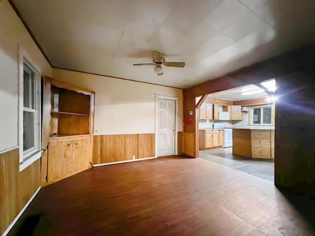 interior space featuring ceiling fan, wood walls, and light wood-type flooring