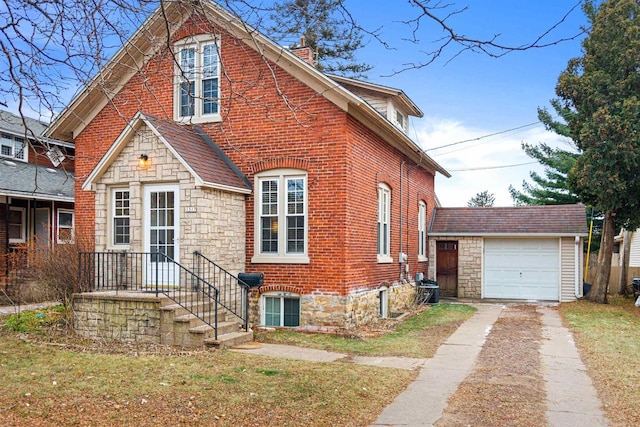 view of front of home with a garage, an outbuilding, and a front lawn