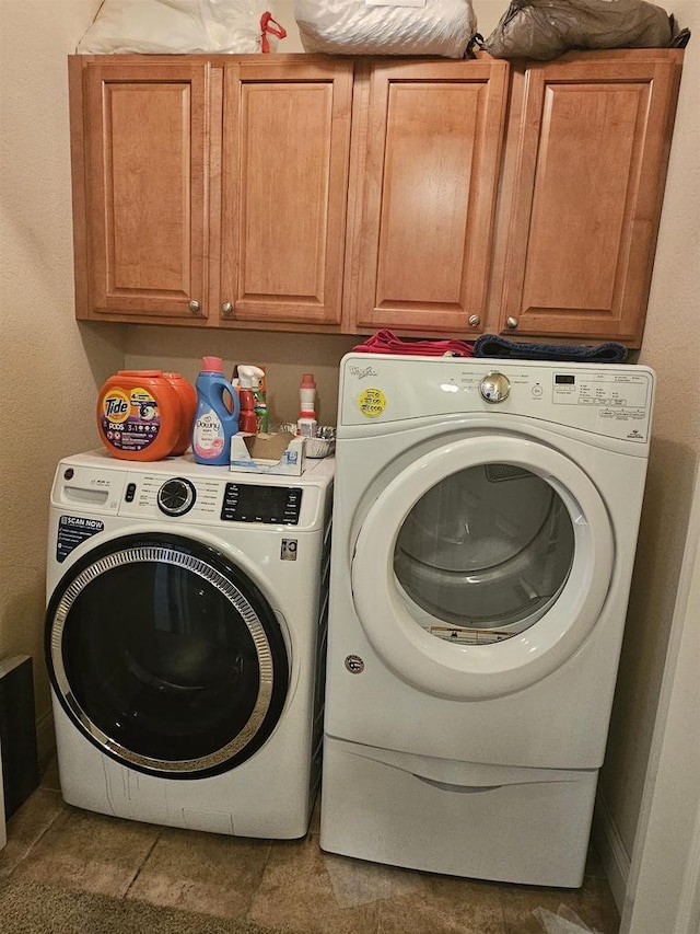 clothes washing area featuring cabinets, tile patterned flooring, and washer and dryer