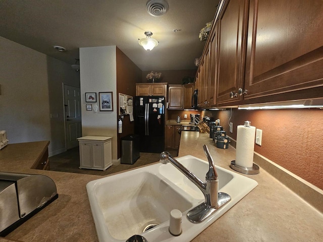 kitchen featuring black appliances, dark carpet, and sink