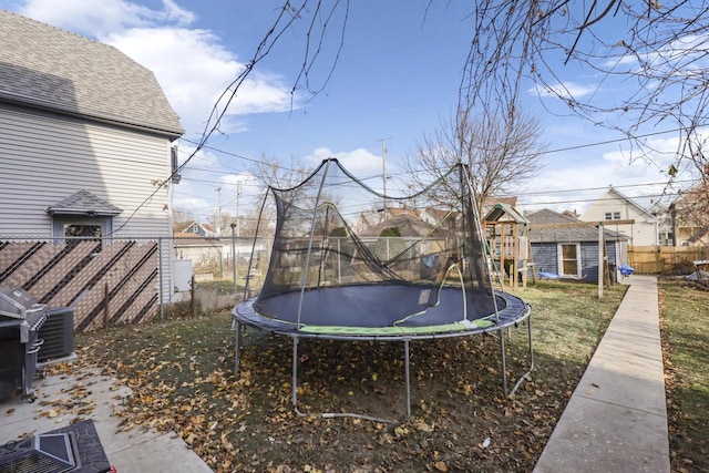 view of yard featuring an outdoor structure and a trampoline