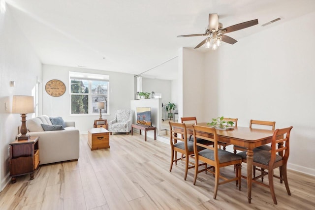 dining area with ceiling fan and light hardwood / wood-style floors