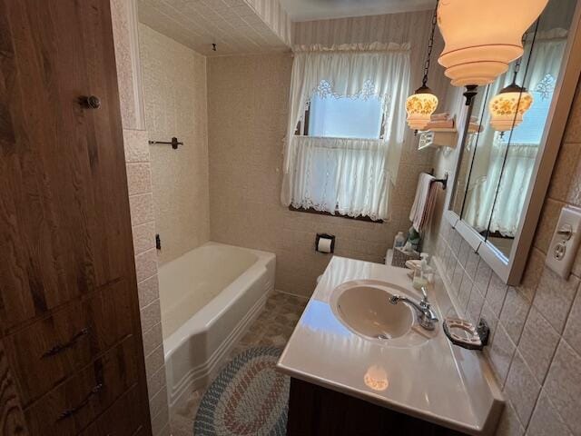 bathroom featuring vanity, tile walls, a bathing tub, and backsplash