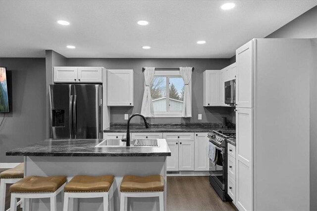 kitchen with a kitchen island, sink, white cabinetry, and stainless steel appliances