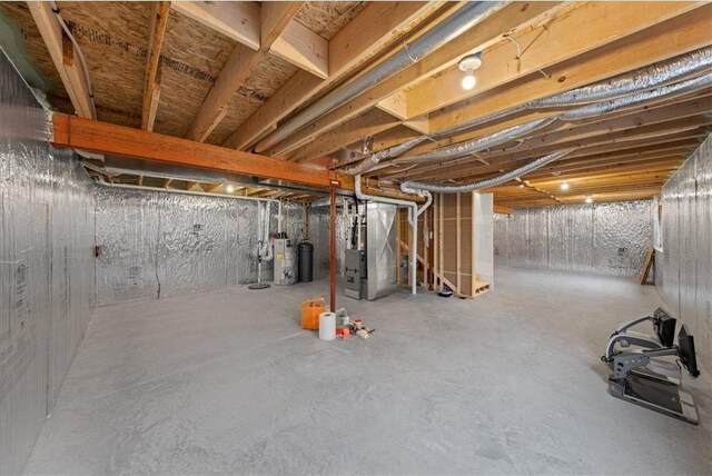 basement featuring heating unit and water heater