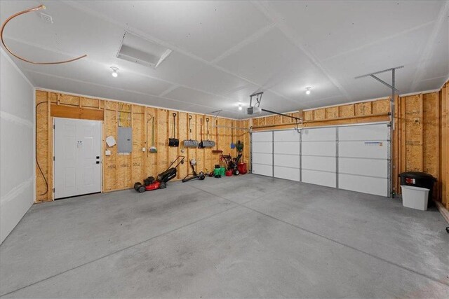 garage with a garage door opener and electric panel