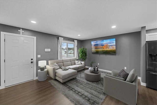 living room featuring dark hardwood / wood-style flooring and a textured ceiling